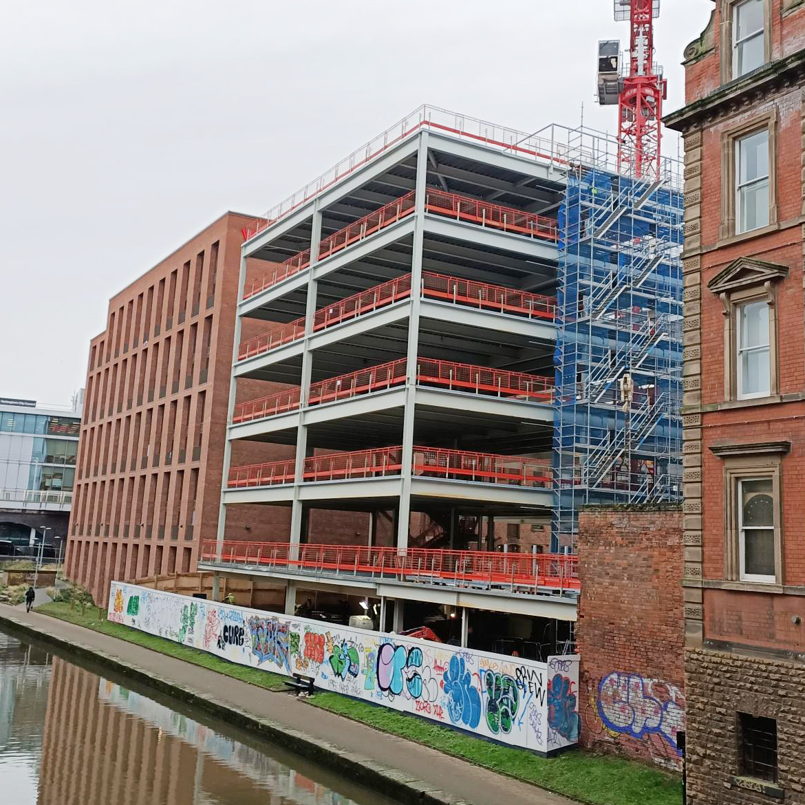 Station Street site beside a canal with construction edge protection barriers on all storeys